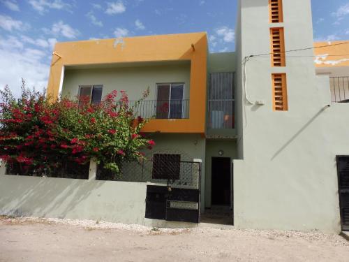 a house with flowers on the side of it at La Femme Noire in Joal-Fadiout