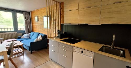 une cuisine avec un canapé bleu dans le salon dans l'établissement Appartement 2 chambres vue montagne panoramique, à Bagnères-de-Bigorre