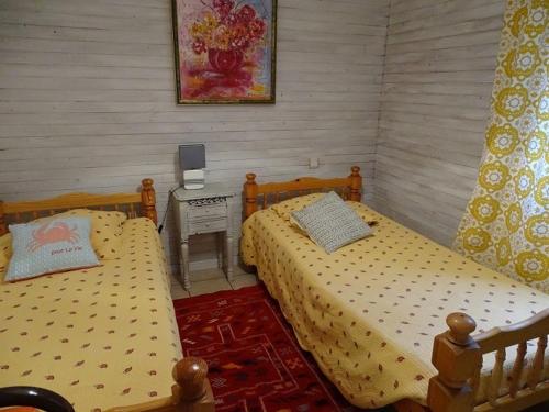 - une chambre avec 2 lits et une table avec un téléphone dans l'établissement Petite maison avec piscine privée, à Marsalès