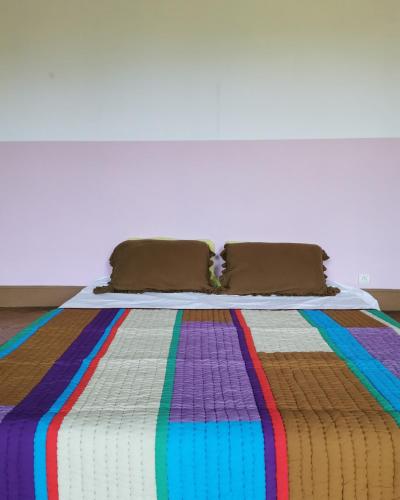 - un lit avec une couverture colorée dans l'établissement La Manufacture Royale de la Bonde Chambre 3, à Cuxac-Cabardès