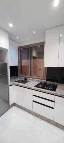 a white kitchen with a sink and a stove at alhoceima egara miniI in Al Hoceïma