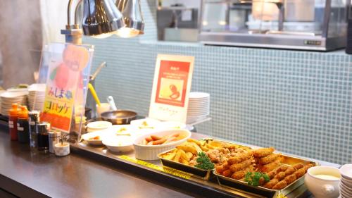a buffet of food on a counter in a restaurant at Dormy Inn Mishima in Mishima