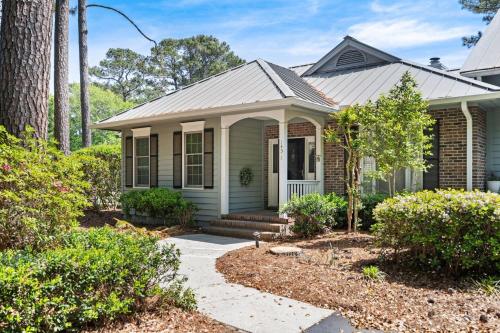 une petite maison verte avec une terrasse couverte dans l'établissement 145-1 9th Hole condo by Peace Vacations, à Pawleys Island