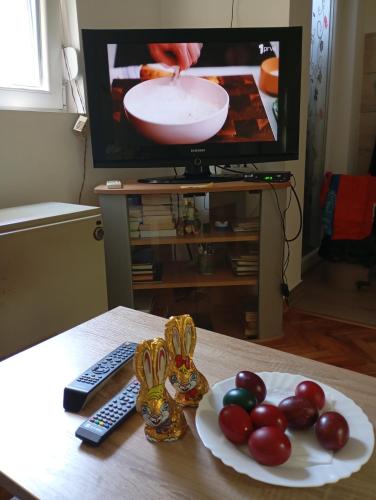 a table with a plate of fruit and a television at Nataly Apartment in Belgrade