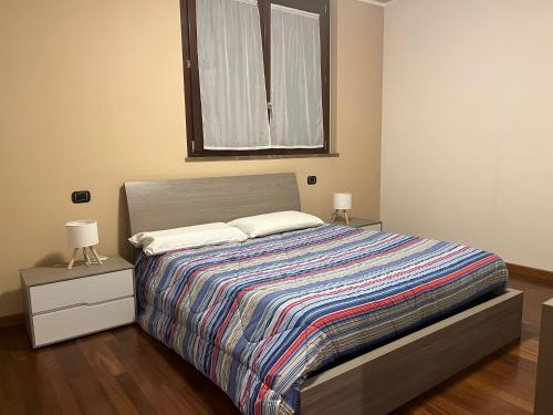 a bedroom with a bed with two lamps and a window at GreenForum in Assago