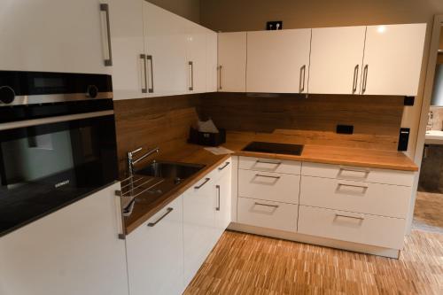 a kitchen with white cabinets and a sink at Cavallestro Deluxe in Kitzingen