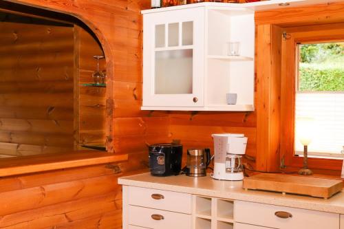 a kitchen with white cabinets and a counter top at Holzhaus Hubertus mit Sauna und Kamin in Meschede