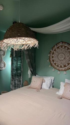 une chambre avec un lit blanc et un mur vert dans l'établissement Gite chez mary au domaine du château de ragny, à Savigny-en-Terre-Plaine