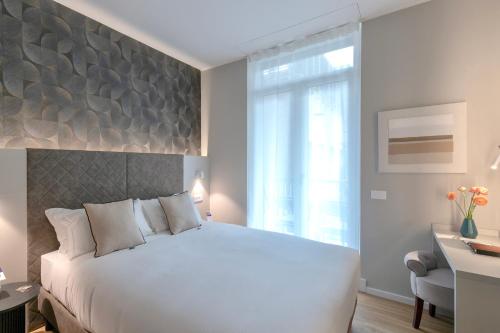 a bedroom with a large white bed and a desk at AH - Duomo Signature in Milan