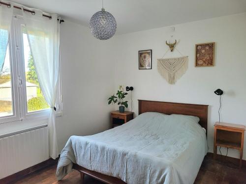 une chambre blanche avec un lit et une fenêtre dans l'établissement Maison de campagne à 12 min de la première plage, à Pluduno