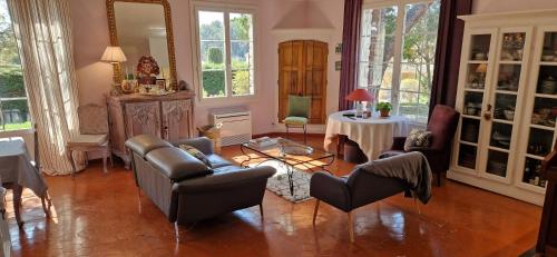 un salon avec des chaises, une table et des fenêtres dans l'établissement Villa Provençale 6 -AC-Pool, à Éguilles