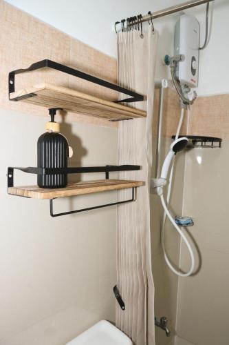 a bathroom with wooden shelves above a toilet at DMall Central Stn 2 Near Beach in Boracay