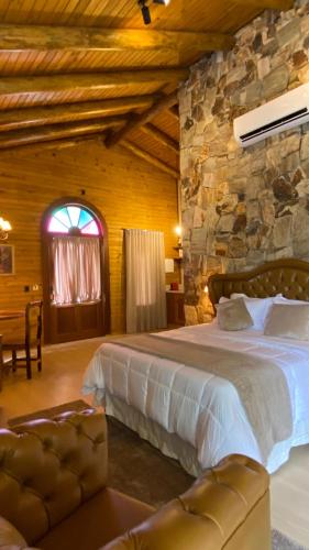 a bedroom with a large bed and a stone wall at La Nostra Terra in Nova Veneza