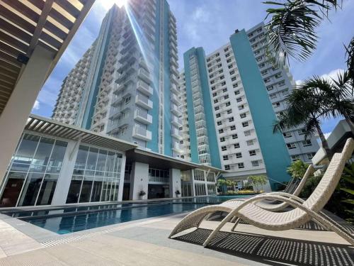 a hotel with a swimming pool and tall buildings at Mesavirre Garden Residences Condo Bacolod in Bacolod