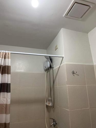 a bathroom with a shower with a shower curtain at Mesavirre Garden Residences Condo Bacolod in Bacolod