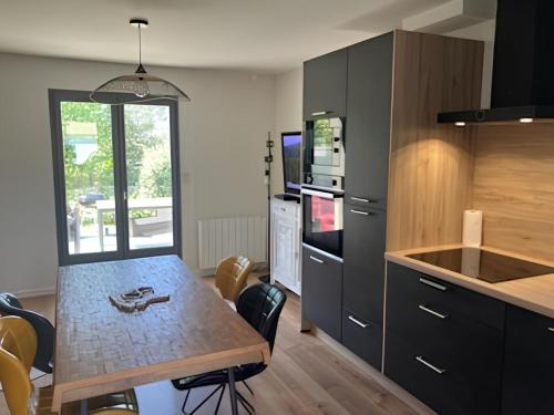 Il comprend une cuisine avec une table en bois et un comptoir. dans l'établissement Maison à 150m de l’océan, à Batz-sur-Mer