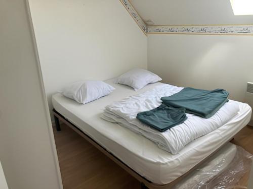 un lit avec deux oreillers dessus dans une chambre dans l'établissement Maison à 150m de l’océan, à Batz-sur-Mer