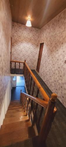 a wooden staircase in a room with a stone wall at White House in Srinagar
