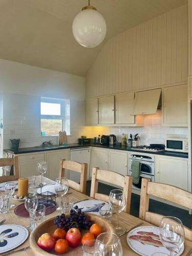 a kitchen with a table with a bowl of fruit on it at Belmullet Beach House Retreat in Belmullet