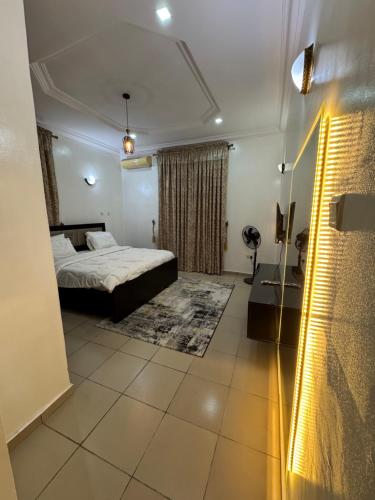 a bedroom with a bed and a shower in a room at EFFAZ Apartments Airport Road Lugbe in Abuja