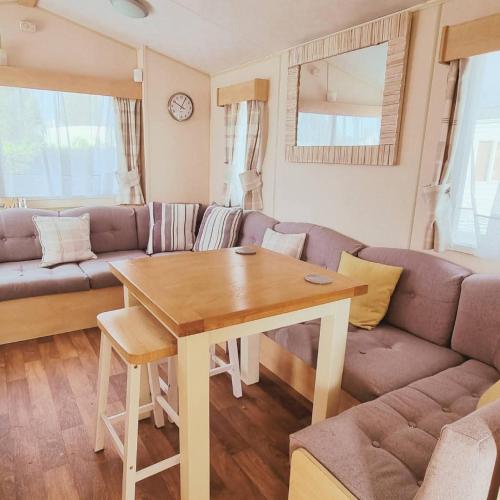 a living room with a couch and a table at Firs Holiday Home At Southview, Skegness in Winthorpe