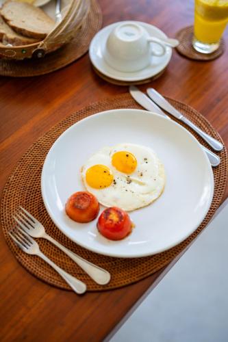 a plate with two eggs and tomatoes on a table at Villa Perle an Idyllic Luxury Retreat in Karangasem