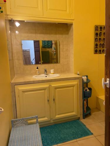 une salle de bain avec un lavabo et un miroir dans l'établissement Le petit velo rouge, à Arles