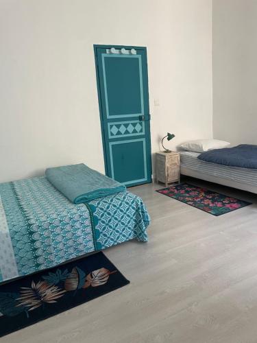 une chambre avec deux lits et un miroir dans l'établissement Le petit velo rouge, à Arles