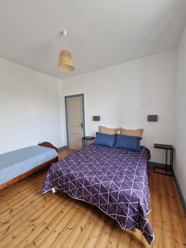 une chambre avec un lit avec une couette violette dans l'établissement La Ria Appartement Douarnenez, à Douarnenez