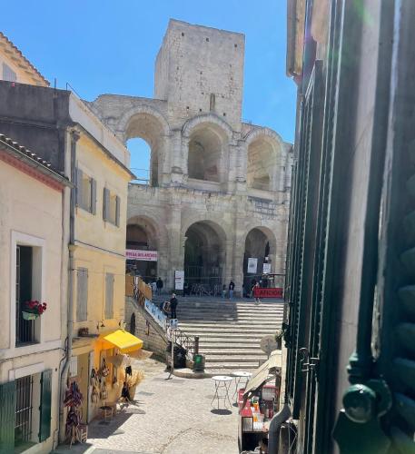 Elle offre une vue sur un grand bâtiment avec des escaliers et un château. dans l'établissement Le petit velo rouge, à Arles
