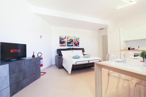 una camera da letto con un letto, una tv e un tavolo di Dimora del Corso - L'Aquila a L'Aquila