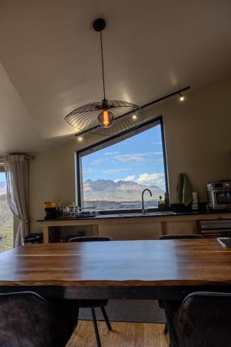 a kitchen with a table and a large window at Skaam Cabin Luxe Hideaway with a Naughty Side in Wolseley