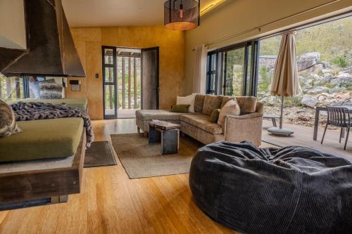 a living room with a couch and a bed and a room with a couch at Skaam Cabin Luxe Hideaway with a Naughty Side in Wolseley