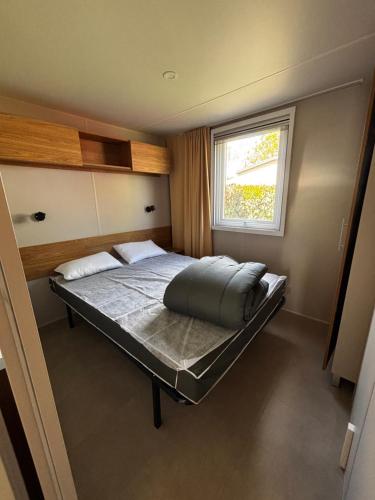 - une petite chambre avec un lit et une fenêtre dans l'établissement A louer mobil home 2 chambres à Siblu La Réserve à Gastes, à Gastes