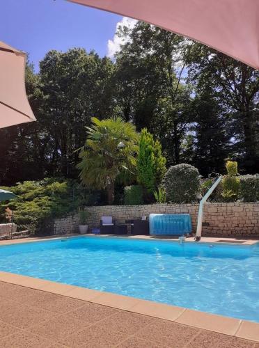 une grande piscine bleue dans une cour dans l'établissement Gîtes du Bois de Bontemps, à Sarlat-la-Canéda