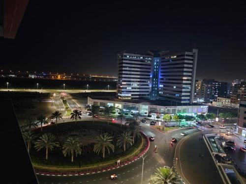 una calle de la ciudad por la noche con coches y edificios en Dubai Silicon Oasis Staycation, en Dubái
