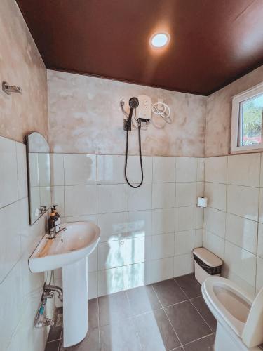 a bathroom with a shower and a sink at Pantropiko Lodge in El Nido