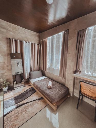a small room with a bed and some windows at Pantropiko Lodge in El Nido