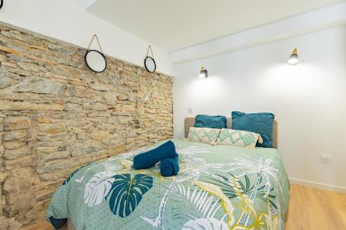 une chambre avec un lit avec un mur en pierre dans l'établissement Le Gite Végétal, à Carcassonne