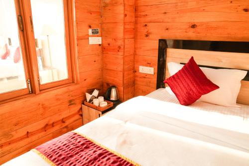 a bedroom with a bed in a wooden cabin at Mountain BNB Hartola in Rāmgarh
