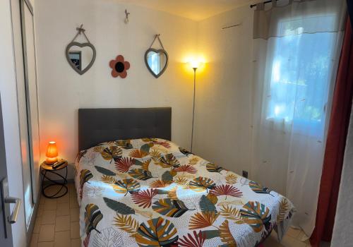 - une chambre avec un lit et une couette en fleurs dans l'établissement CAP dagde proche naturiste, au Cap d'Agde