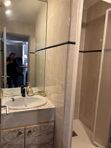 une salle de bain avec un lavabo et un miroir dans l'établissement CAP dagde proche naturiste, au Cap d'Agde