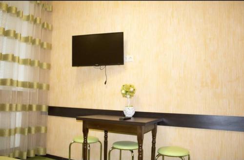 a room with a table with stools and a tv on a wall at Studio in the city center metro Historical Museum in Kharkiv