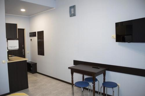 a room with a table and two blue stools at Studio in the city center metro Historical Museum in Kharkiv