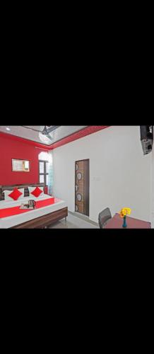 a bedroom with two beds and a table and chairs at Hotel Joyous inn in Ghaziabad