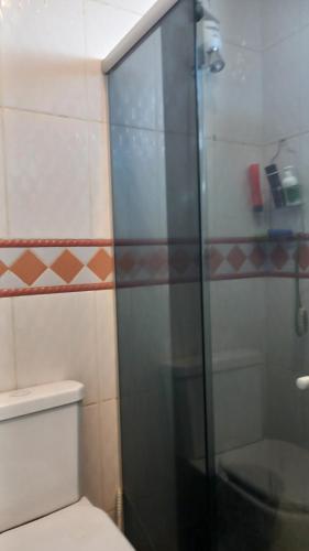 a bathroom with a glass shower with a toilet at Apartamento in Montes Claros