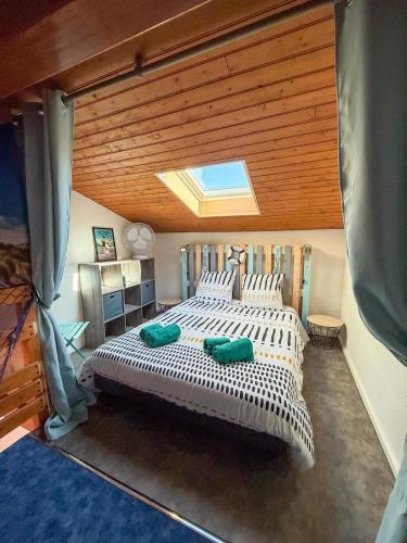une chambre avec un grand lit avec une lucarne dans l'établissement Maison soleil d'or proche mer, à Vaux-sur-Mer