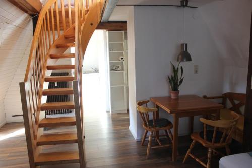 una escalera en una habitación con mesa y sillas en Beautiful loft near city and Danube, en Neu-Ulm