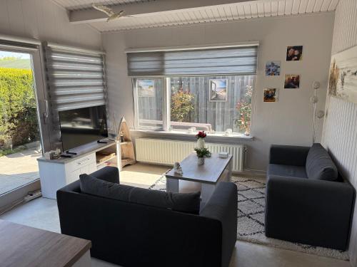 a living room with two couches and a table at Sunny escape hoek van holland in Hoek van Holland