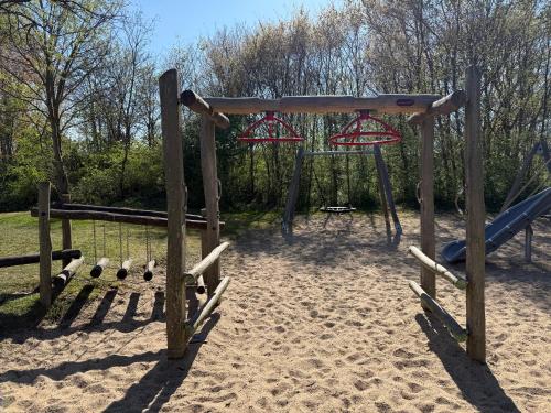a playground with two swings in the sand at Sunny escape hoek van holland in Hoek van Holland